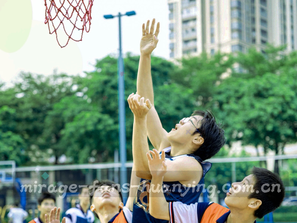 逆光下校园操场上踢球的人群剪影